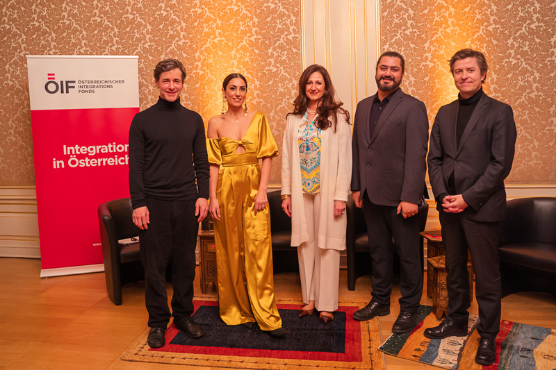 Fünf Personen stehen zusammen vor einem Banner des Österreichischen Integrationsfonds.