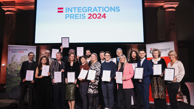Gruppenfoto von Preisträgern des Integrationspreises 2024, alle halten Zertifikate in der Hand.