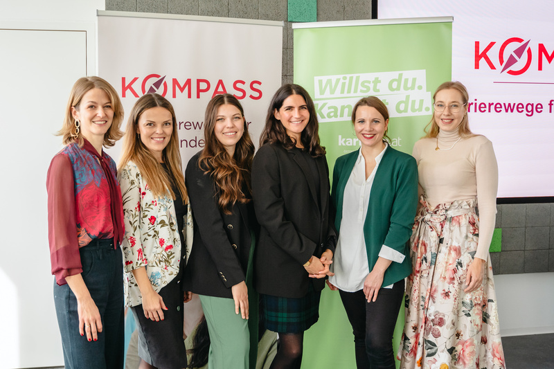 Sechs Frauen stehen gemeinsam vor zwei Bannern, die für ein Karrierenetzwerk werben.