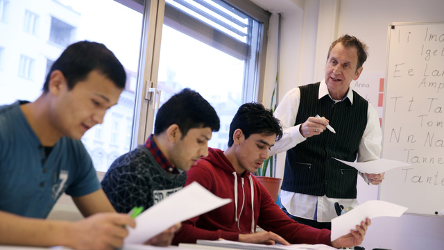 Ein Lehrer steht an der Tafel und erklärt etwas