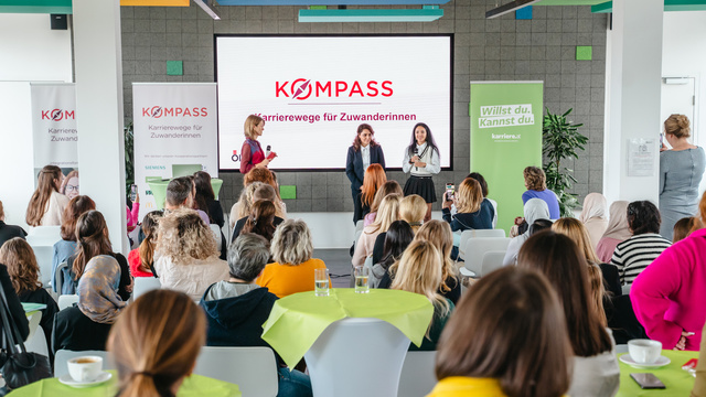 Veranstaltung mit Präsentationen und Diskussionen über Karrierewege für Zuwanderinnen in einem modernen Raum.