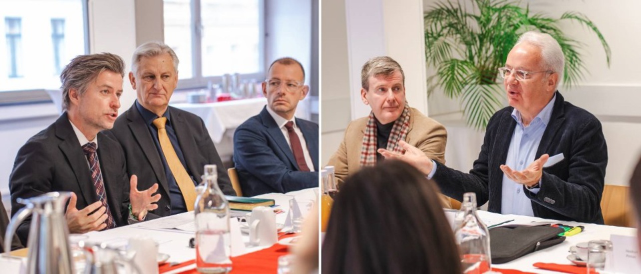 Diskussion am Tisch mit mehreren Personen, die sich aktiv austauschen.