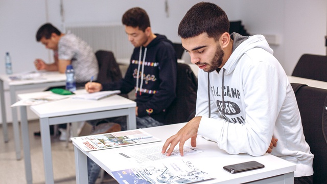 Gruppe von Männern sitzt in einem Deutschkurs.