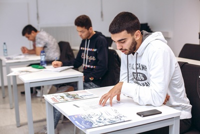 Gruppe von Männern sitzt in einem Deutschkurs.