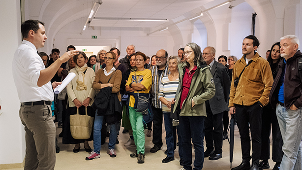 Eine Gruppe von Menschen hört einem Redner aufmerksam zu.